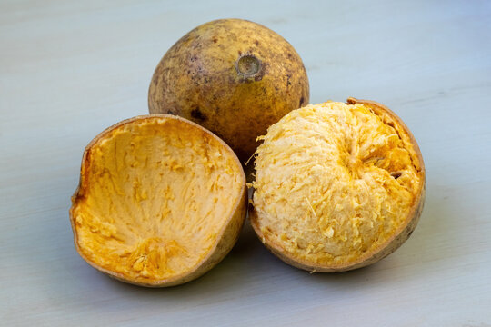 Whole and broken wood apple or bael fruit, showing its ripe, juicy flesh interior. Its scientific name is Aegle marmelos, also known as stone apple, Bengal quince, Indian quince, or Bel.