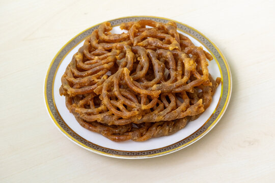 Delicious Shahi jilapi or jalebi on a white ceramic plate. It is a popular and traditional sweetmeat originating from Chowk Bazaar in Old Dhaka, Bangladesh, and is very popular in the country.