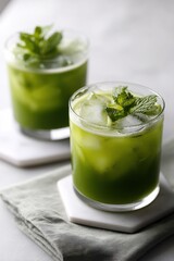 A pair of refreshing green drinks garnished with mint, capturing an inviting summer vibe ideal for gatherings.