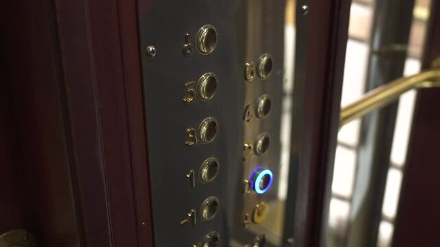 Paris, France, Close-up of a vintage brass elevator control panel in Galeries Lafayette, with glowing buttons and elegant, historic Art Deco design elements.