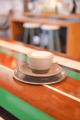 Coffee cup on a wooden table in a cozy cafe environment