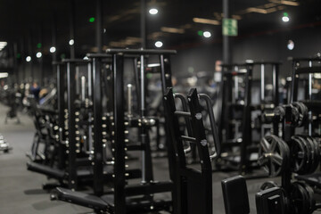 Interior of modern gym with black weight training machines for beginners and professional athletes....