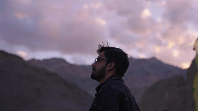 4K footage of a hiker reaching the summit just in time to enjoy the last golden rays of sunset.