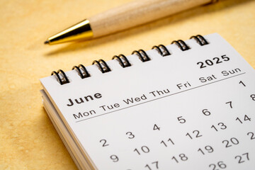 June 2025 - small spiral desktop calendar, time and business concept