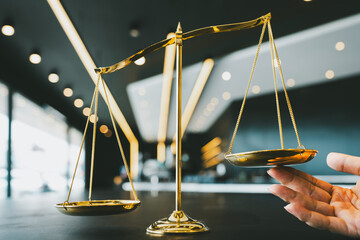 The golden scales representing justice but a hand appears to tilt the fair scales. The idea of...