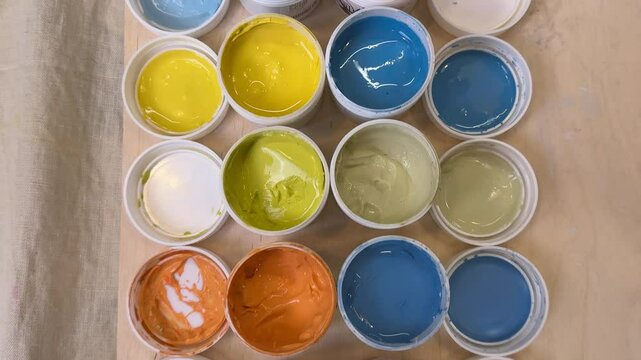 view from above of colorful jars with glazes and engobes