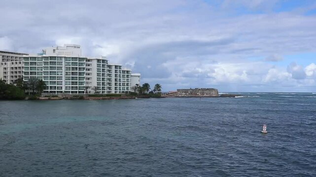 waves on the beach in front of luxury hotel in the condado neighborhood of old san juan puerto rico (famous tourism travel destination caribbean sea) ocean waves water sport paddle boarding surf water