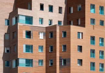 Modern brick building with blue-tinted windows in a geometric design, showcasing contemporary architecture.