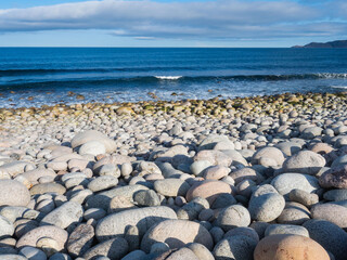 Round stones on the Dragon's Eggs beach in Teriberka, on the Barents Sea in the Murmansk region of...