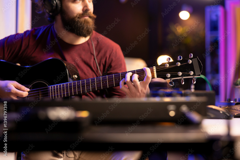 Poster musician playing guitar and uses mixing gear to create new music, looking at daw software interface 