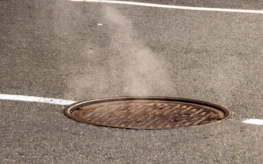 Vapor saliendo de una arqueta de Nueva York, EE.UU. Alcantarilla en el asfalto de la quinta avenida de Nueva York.