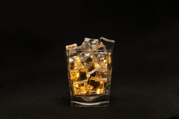 Opaque transparent ice filled drink short glass yellow tungsten light flame smoke fog on black...