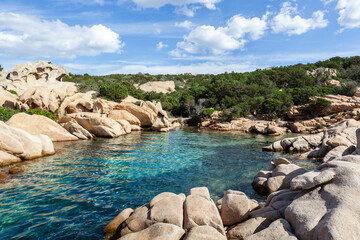 A stunning view of the Sardinian coast, with turquoise waters lapping against rocky shores. The emerald sea and blue sky. Picturesque scene. Holiday destination in Italy.