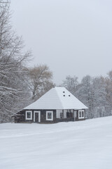 Snow-covered traditional wooden house in a winter scenery in Carpathian mountains, Romania