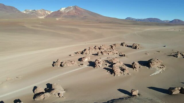 Drone glides across wide red desert plains in Bolivia&rsquo;s Siloli region with distant rocky hills