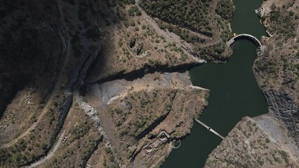 Aerial view of the Foz Côa river and the remains of the works for the build of the new dam that was stopped after the findings of the paleolithic rock art. Drone moving down over the old dam.