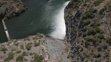 Aerial view of the Foz Côa river and the remains of the works for the build of the new dam that was stopped after the findings of the paleolithic rock art. Drone moving forward, camera tilting down.