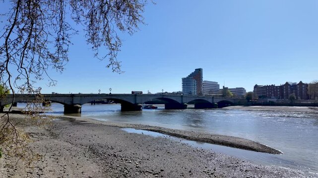 Putney Bridge spanning River Thames, with clear skies and serene waters visible.