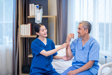 Obraz premium Senior Asian man patient get medical service visit from caregiver nurse at hospital while doing physical therapy to shoulder stretching for muscle pain in health care and pension welfare