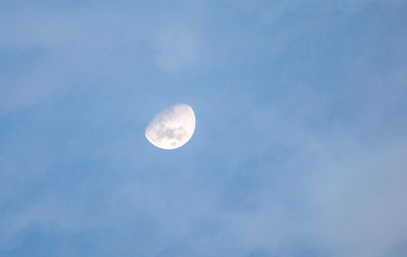 A large moon is in the sky above a blue sky - Powered by Adobe