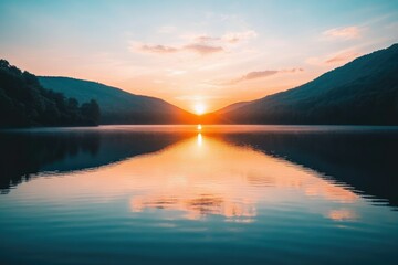 Sunset over calm lake between mountains, reflecting vibrant colors in still water.