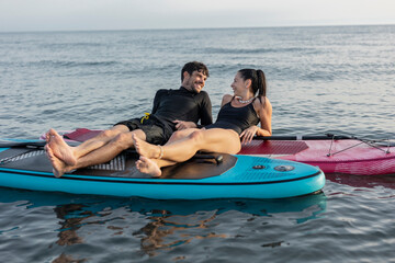 Couple relaxing on paddleboards in the ocean