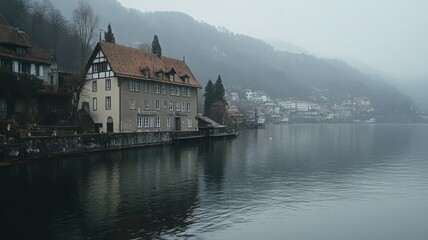 Fototapeta premium Misty Lake and Hillside Building: Tranquil Water Reflection