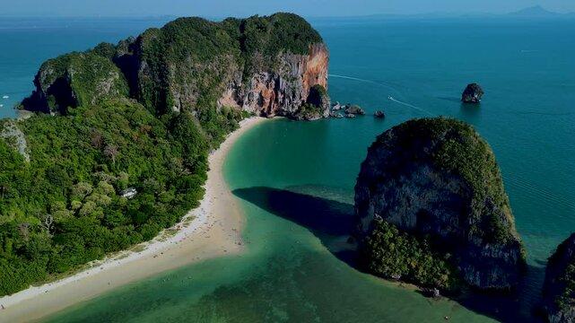 Crystal-clear waters embrace the sandy shores of Railay beach Krabi Thailands breathtaking coastline, showcasing dramatic cliffs and vibrant greenery.