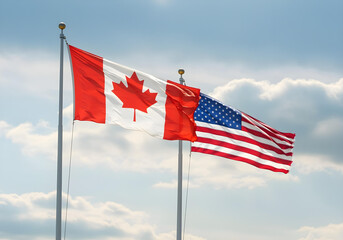 canadian and american flags waving together on flagpoles against blue sky with clouds symbolizing international cooperation and north american friendship
