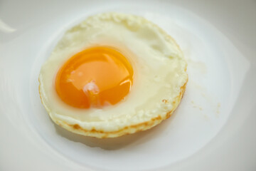 Fried egg on white dish close up
