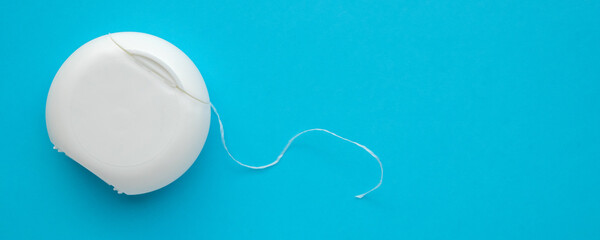 dental floss in case on blue background