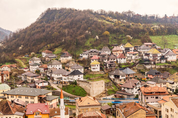 Fototapeta premium Panoramic view of the old residential area in Travnik, Bosnia and Herzegovina, with traditional houses on a hillside and spring greenery. Photographed on March 25, 2025.