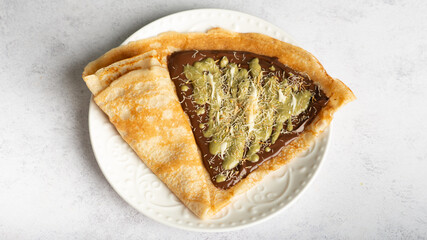 pancake with dubai chocolate on yellow background. Dubai chocolate kunafa pancakes