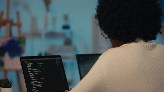 African American woman programmer coding on laptop, software testing, developer
