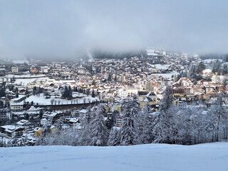 Fototapeta premium Top view of winter Ortisei in snowy fog.