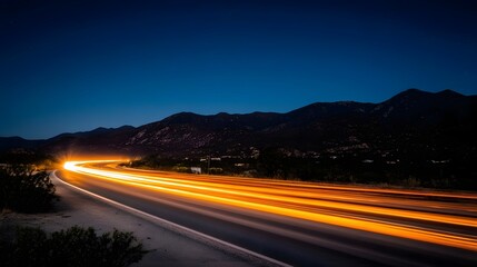 Fototapeta premium Long Exposure of Highway at Night with Mountains in the Background