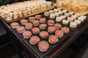 Elegant Canapés And Finger Foods With Salami, Bread, And Creamy Fillings