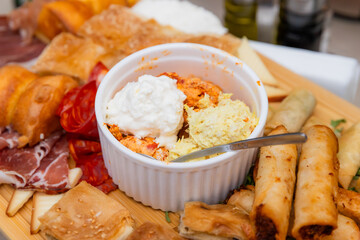 Assorted Gourmet Appetizers Platter With Three Dips On A Rustic Wooden Board