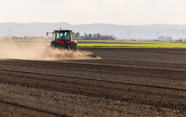 Obraz premium Tractor is preparing the land at dusk