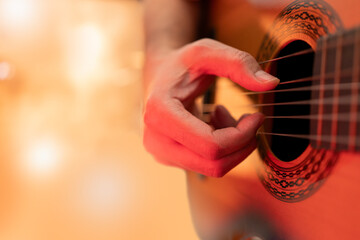 Fototapeta premium An unrecognizable man playing an acoustic guitar on the stage