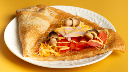 thin pancakes with tomato and cheese filling. serving salty food on yellow background. Thin pancakes with fillings
