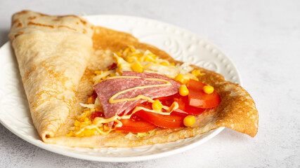 thin pancakes with tomato and cheese filling. serving salty food on yellow background. Thin pancakes with fillings