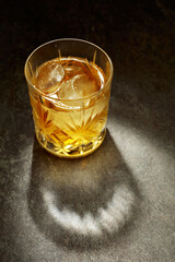 Whiskey with ice in a crystal glass.