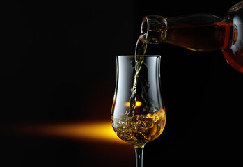 Rum being poured from a bottle into a glass.