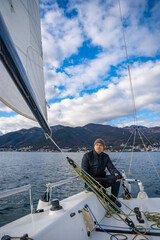 Man sailing a sports yacht in the Kotor Bay, Montenegro, showcasing adventure, freedom, and nautical sport.