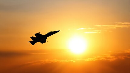 A silhouette of a fighter jet flying against a vibrant sunset, showcasing a blend of oranges and yellows in the sky.