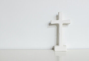 Naklejka premium small white cross crucifixion figurine on white background