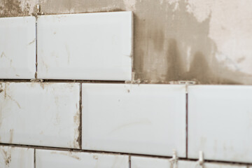 Facing walls with decorative tiles, laying tiles on the walls in the kitchen at home