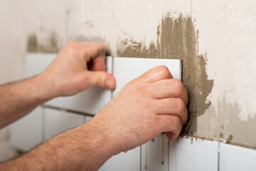 Facing walls with decorative tiles, laying white tiles