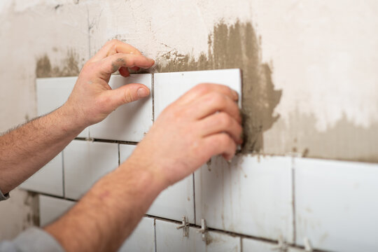 Facing walls with decorative tiles, laying white tiles